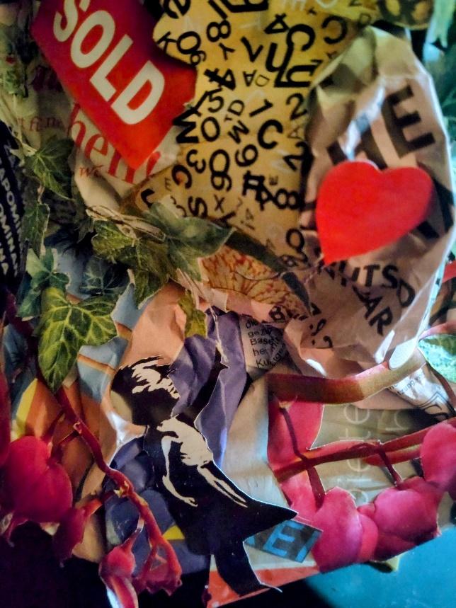Close detail of the collage sleeve made from magazine fragments, lettering, leaves and flowers.