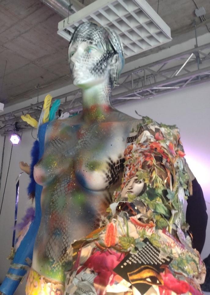 A mannequin decorated with a richly patterned collage sleeve and arm.